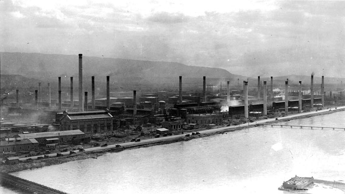 The Midwest Oil Company Refinery in Casper, shown here around 1920 with the North Platte River in the foreground, was later bought by Standard Oil. Blackmore Collection, Casper College Western History Center.