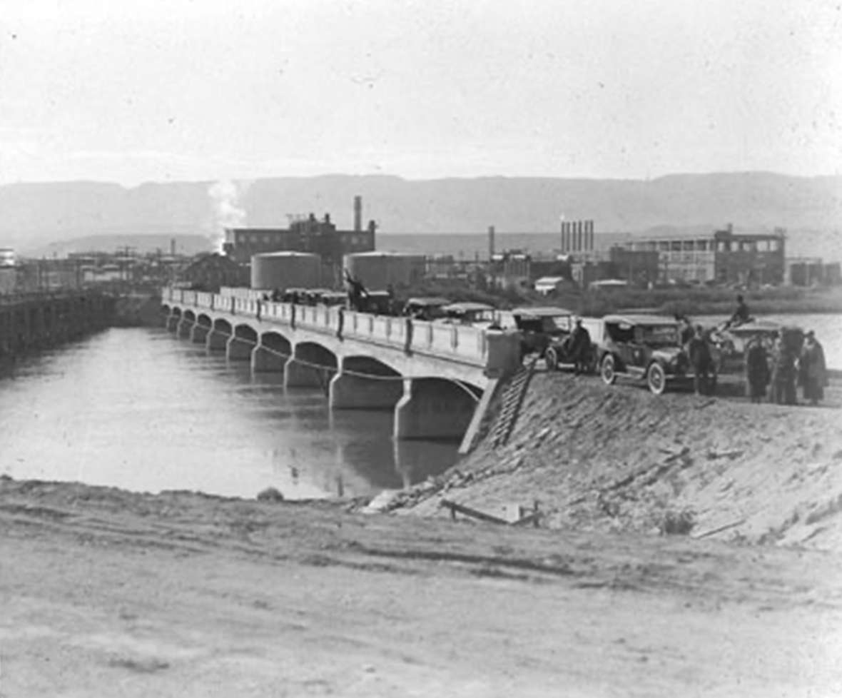 The 1920 Park-to-Park caravan paused in Casper, Wyo., on a new concrete bridge over the North Platte, with the Midwest Refinery and Casper Mountain in the background. Park County Archives. The 1920 Park-to-Park caravan paused in Casper, Wyo., on a new concrete bridge over the North Platte, with the Midwest Refinery and Casper Mountain in the background. Park County Archives.