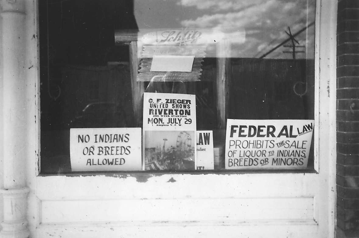 Signs like this in the window of a Lander, Wyo., bar in 1934 were not uncommon in towns bordering reservations in the American West. The location is 126 Main St., today’s Lander Bar. Lander Pioneer Museum. Signs like this in the window of a Lander, Wyo., bar in 1934 were not uncommon in towns bordering reservations in the American West. The location is 126 Main St., today’s Lander Bar. Lander Pioneer Museum.