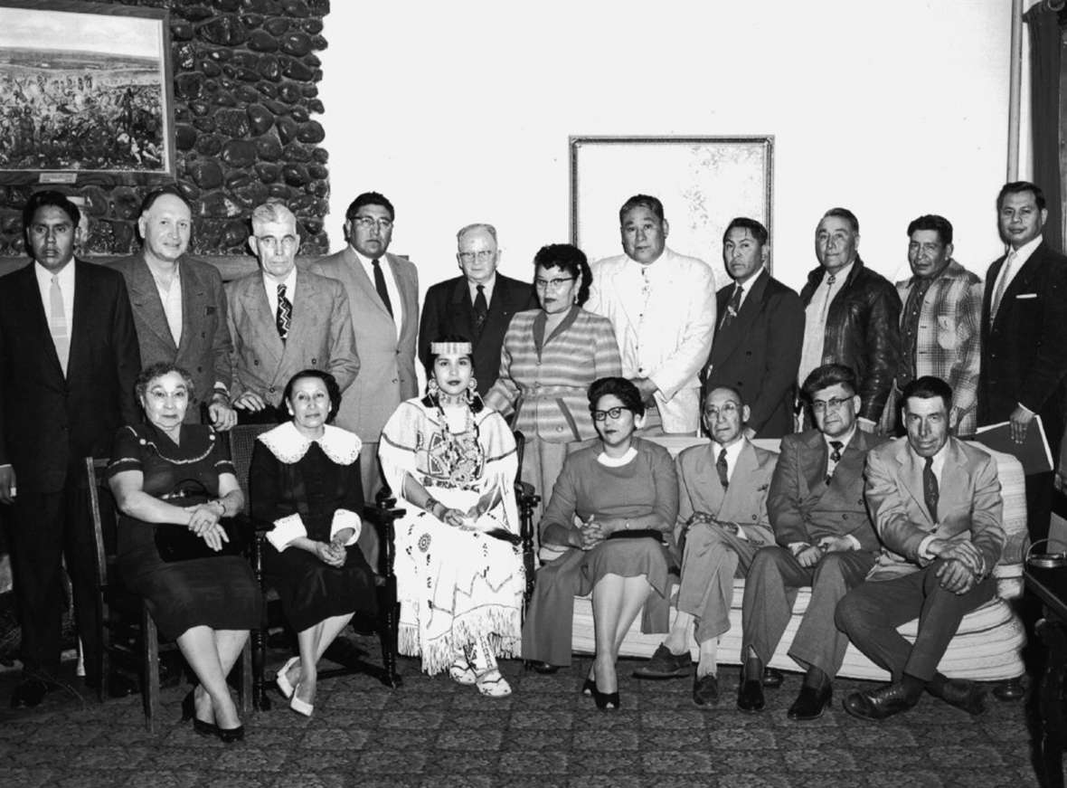 From early on, All American Indian Days leadership included a General Indian Committee. Standing, left to right: Black Beaver, Louis Tellier, Tom Harwood (vice chair), Peter Red Horn, Howard Sinclair (secretary), Ella McCarty, Martin Cross, Joe Medicine Crow, Tom Yellowtail, Jesse Old Man, Brummett Echohawk. Seated, left to right: Amy McCurdy, Mrs. Tom Harwood, Sandra May Gover (Miss Indian America IV), Matilda Grant, William Shakespeare (vice chair), Arthur Montiac, George Harris (general chairman). THE Wyoming Room, SCFPL. From early on, All American Indian Days leadership included a General Indian Committee. Standing, left to right: Black Beaver, Louis Tellier, Tom Harwood (vice chair), Peter Red Horn, Howard Sinclair (secretary), Ella McCarty, Martin Cross, Joe Medicine Crow, Tom Yellowtail, Jesse Old Man, Brummett Echohawk. Seated, left to right: Amy McCurdy, Mrs. Tom Harwood, Sandra May Gover (Miss Indian America IV), Matilda Grant, William Shakespeare (vice chair), Arthur Montiac, George Harris (general chairman). THE Wyoming Room, SCFPL.