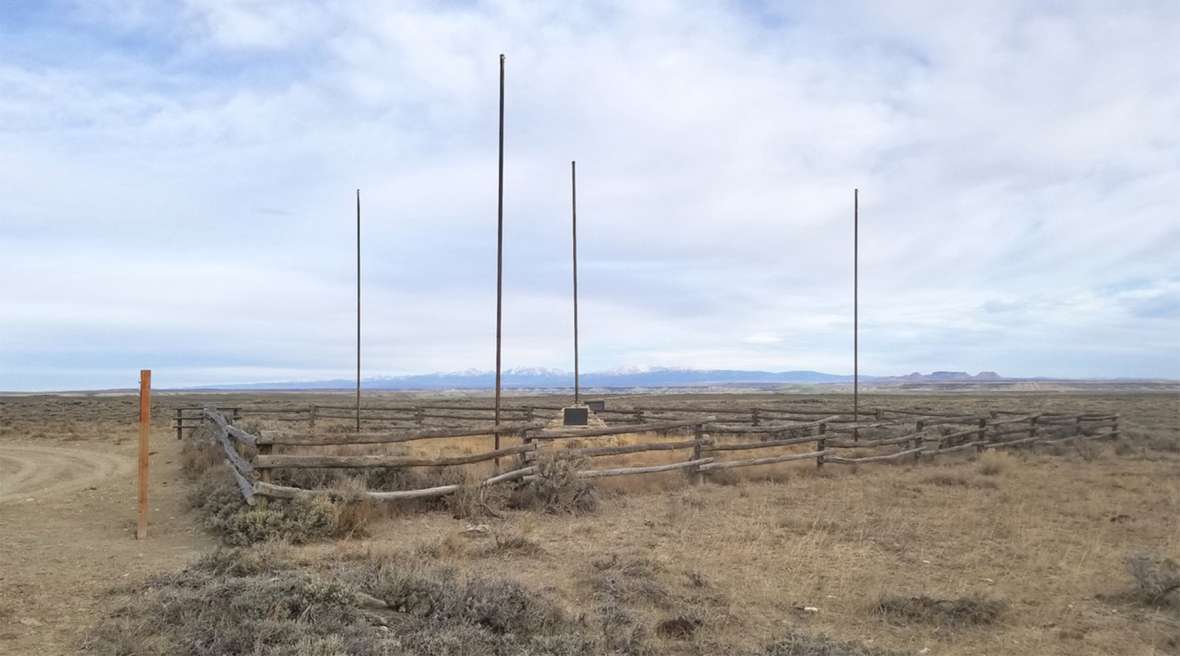 A view to the north at the Tri-Territory Historic Site. The poles are for the flags of Britain, Mexico, France, and, on the stone monument, the United States. The Wind River Range is visible in the distance, with the Oregon Buttes on the horizon on the right. Author photo. A view to the north at the Tri-Territory Historic Site. The poles are for the flags of Britain, Mexico, France, and, on the stone monument, the United States. The Wind River Range is visible in the distance, with the Oregon Buttes on the horizon on the right. Author photo.