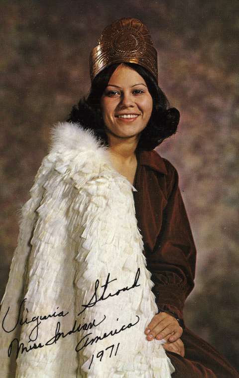 Miss Indian America XVII, Virginia Stroud of Tahlequah, Oklahoma, poses in contemporary clothes with a copper crown and a traditional Cherokee feather cape for her 1971 portrait. She declined to wear a Plains-style beaded buckskin dress, opting instead for trade cloth dresses and this cape, created from more than one thousand feathers sewn to a net backing. She believed contestants should be allowed to appear in contemporary clothing because regalia was not worn as daily dress. Miss Indian America Collection, THE Wyoming Room, SCFPL. Miss Indian America XVII, Virginia Stroud of Tahlequah, Oklahoma, poses in contemporary clothes with a copper crown and a traditional Cherokee feather cape for her 1971 portrait. She declined to wear a Plains-style beaded buckskin dress, opting instead for trade cloth dresses and this cape, created from more than one thousand feathers sewn to a net backing. She believed contestants should be allowed to appear in contemporary clothing because regalia was not worn as daily dress. Miss Indian America Collection, THE Wyoming Room, SCFPL.
